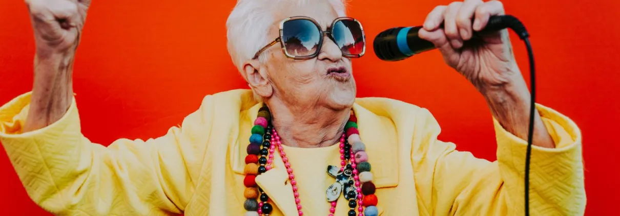 Vibrant senior woman singing into a microphone with joy and energy